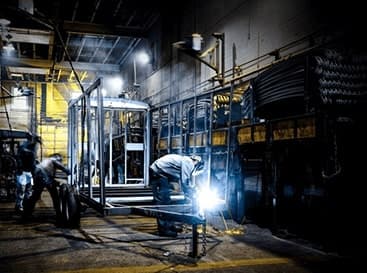 A man welding a TrailersPlus trailer.