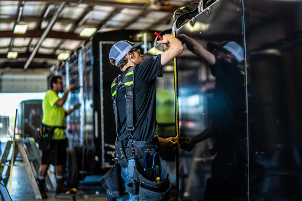 TrailersPlus employee servicing a cargo trailer
