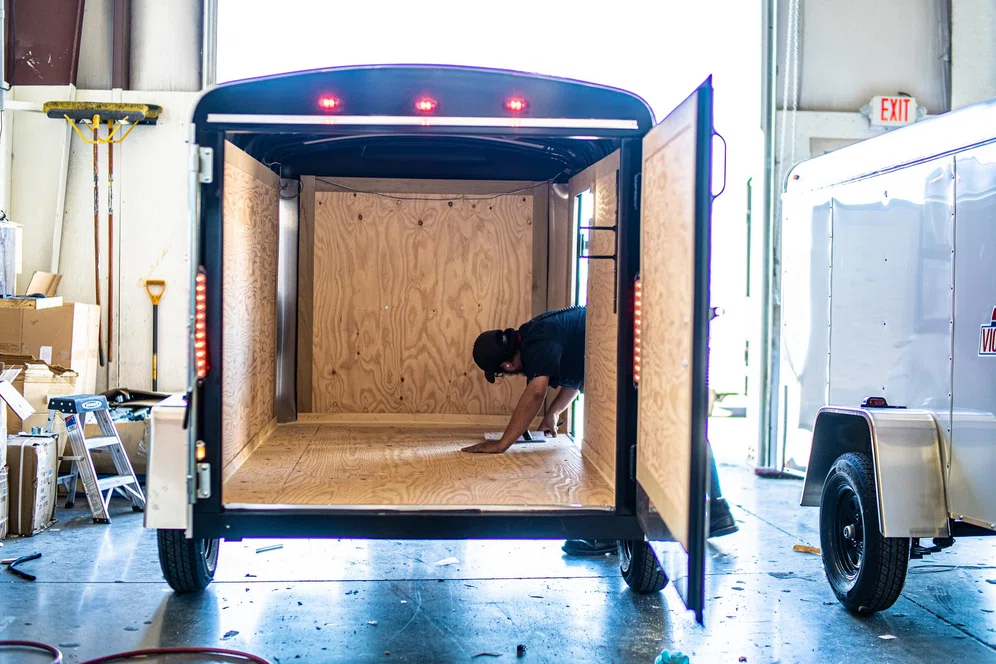 TrailersPlus employee servicing a cargo trailer